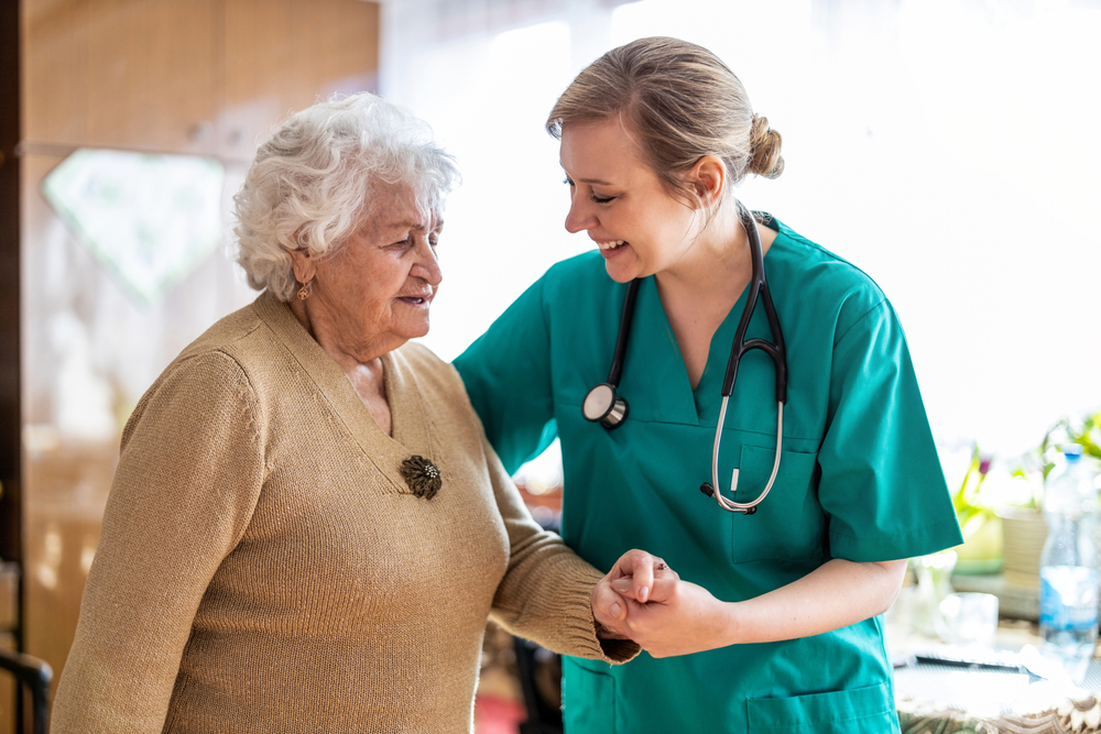 A caregiver walking arm in arm with a senior resident